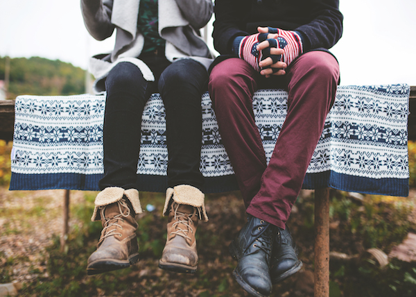 a couple sits on a bench together reflecting on their dating life